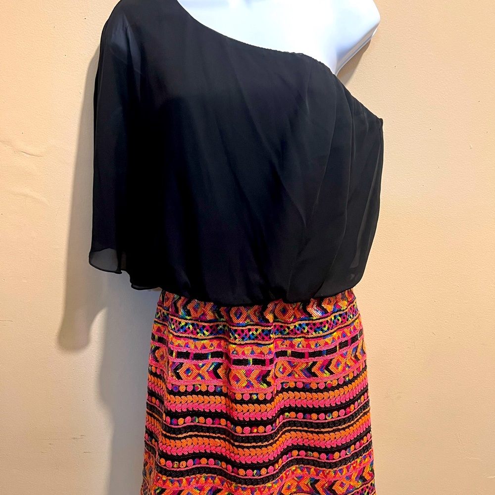 One-shoulder, black upper bodice, bright sequin lower bodice, mid-thigh, sassy